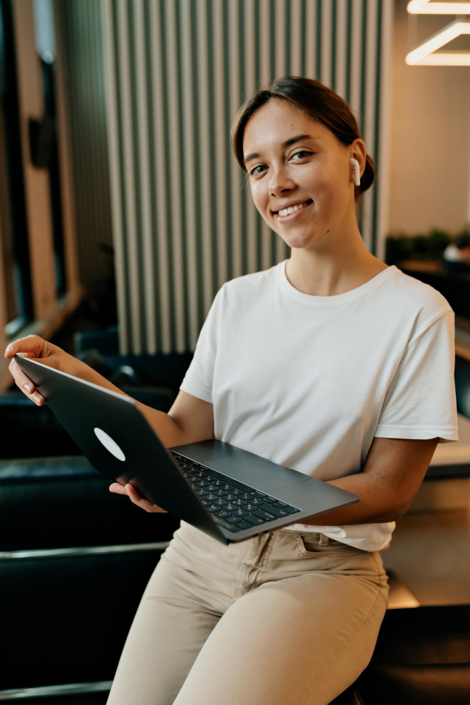 Pessoa sorrindo com notebook nas mãos